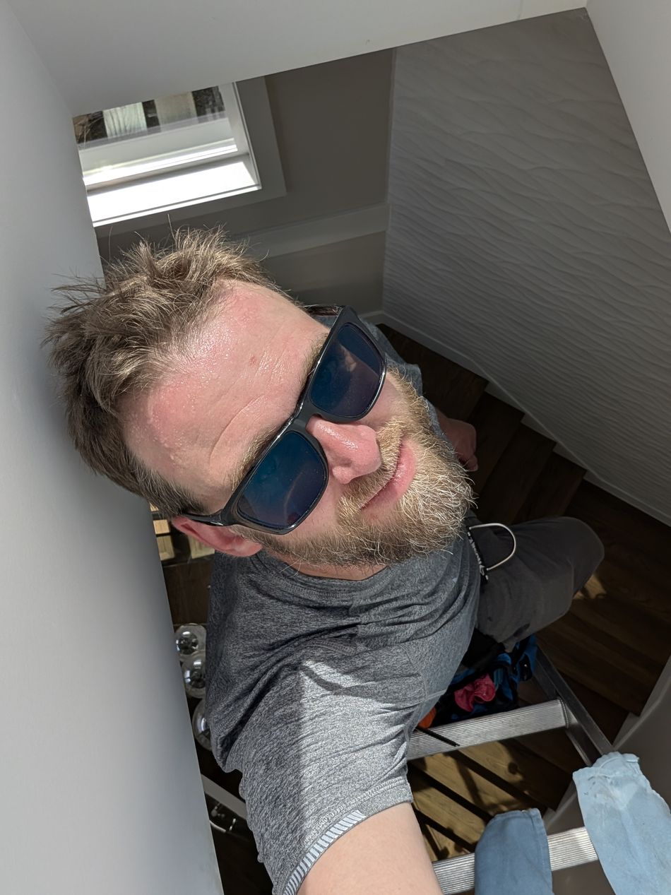 Ian Bonyun, owner of True View Window Cleaning, on a ladder with a squeegee